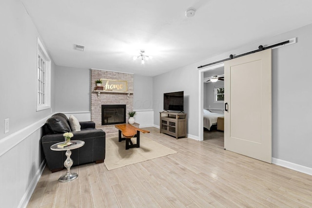966 Larkstone Dr, Columbus, OH 43235 - living room with light wood-style floors, a barn door, and a brick fireplace