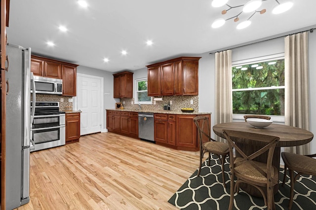 966 Larkstone Dr, Columbus, OH 43235 - kitchen with stainless steel appliances, light wood-type flooring, backsplash, light stone countertops, and recessed lighting