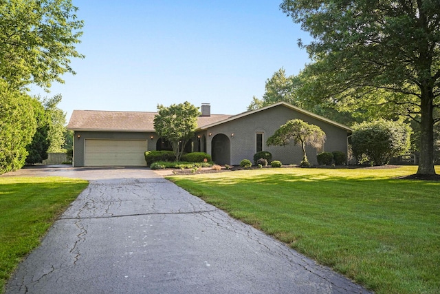 2500 Carriage Rd, Powell, OH 43065 - ranch-style house featuring driveway, an attached garage, a front yard, and a chimney