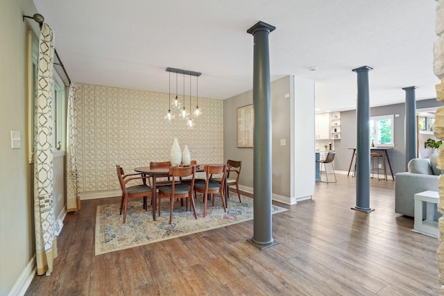 2500 Carriage Rd, Powell, OH 43065 - dining room featuring wood finished floors, ornate columns, and wallpapered walls