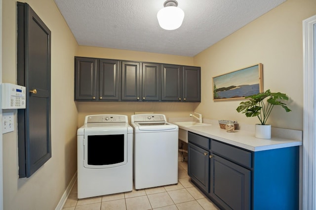 2500 Carriage Rd, Powell, OH 43065 - laundry area featuring cabinet space, washing machine and dryer, a textured ceiling, and light tile patterned floors