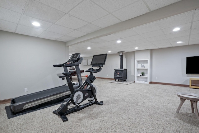 2500 Carriage Rd, Powell, OH 43065 - exercise room featuring carpet flooring, a wood stove, recessed lighting, a drop ceiling, and built in features