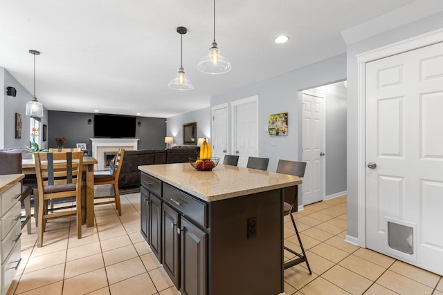 1271 Fareharm Dr, New Albany, OH 43054 - kitchen featuring a breakfast bar, light tile patterned floors, hanging light fixtures, recessed lighting, and a kitchen island
