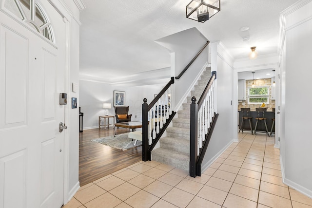 1271 Fareharm Dr, New Albany, OH 43054 - foyer with stairs, light tile patterned floors, and ornamental molding