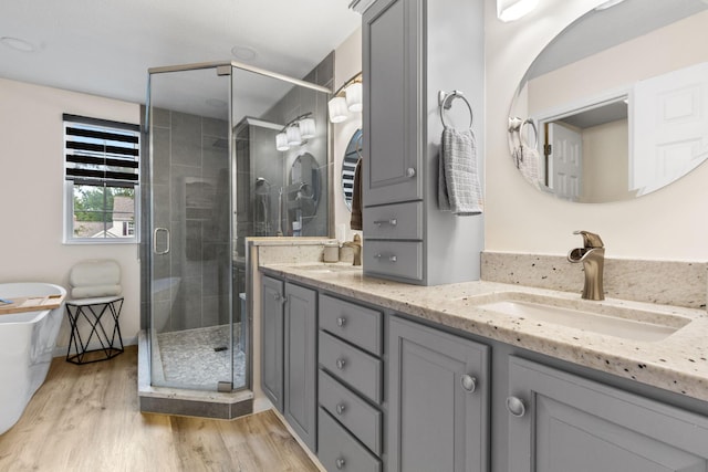 1271 Fareharm Dr, New Albany, OH 43054 - bathroom featuring double vanity, wood finished floors, a stall shower, and a freestanding tub