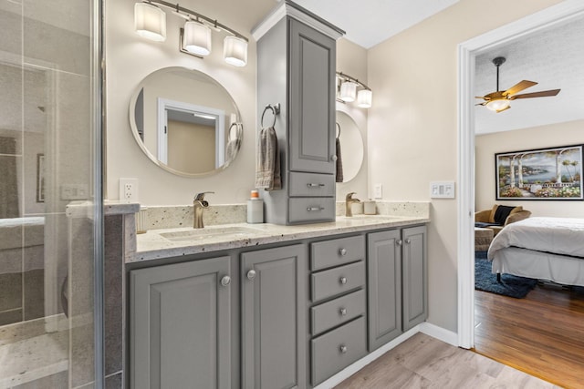 1271 Fareharm Dr, New Albany, OH 43054 - full bathroom featuring double vanity, a ceiling fan, wood finished floors, a shower stall, and ensuite bath