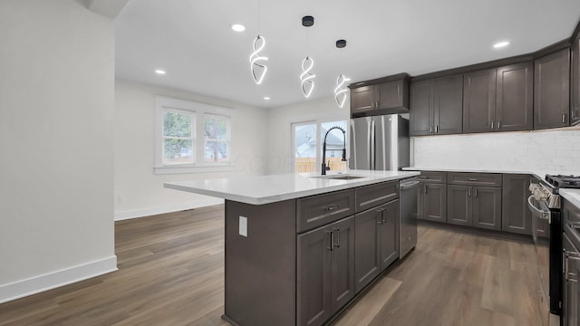 732 Columbus Ave, Washington Court House, OH 43160 - kitchen featuring appliances with stainless steel finishes, dark wood-type flooring, backsplash, a center island with sink, and recessed lighting