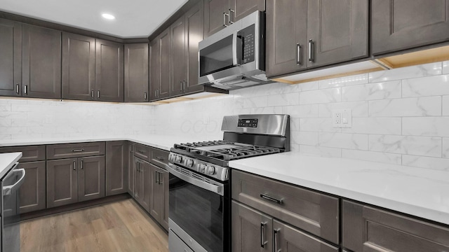 732 Columbus Ave, Washington Court House, OH 43160 - kitchen featuring stainless steel appliances, light countertops, dark brown cabinets, light wood-style floors, and tasteful backsplash