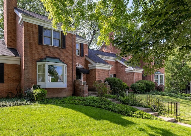 409 N High St, Lancaster, OH 43130 - view of front of house with a front lawn, a chimney, and brick siding