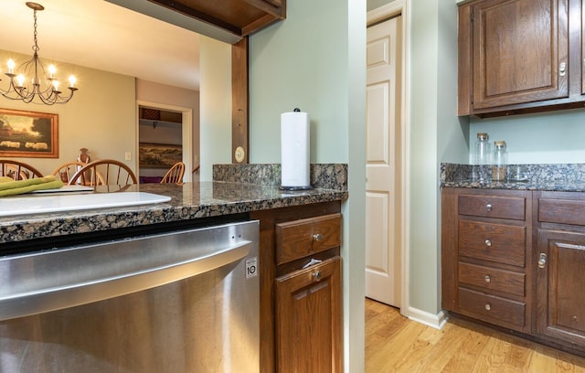 409 N High St, Lancaster, OH 43130 - kitchen with dishwasher, light wood finished floors, a chandelier, decorative light fixtures, and dark stone counters