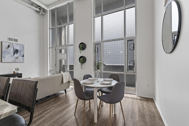 60 E Spring St Unit 220, Columbus, OH 43215 - dining area featuring wood finished floors, a high ceiling, and rail lighting