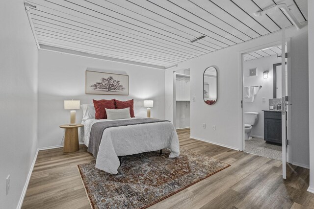 60 E Spring St Unit 220, Columbus, OH 43215 - bedroom featuring wood finished floors, connected bathroom, and a spacious closet