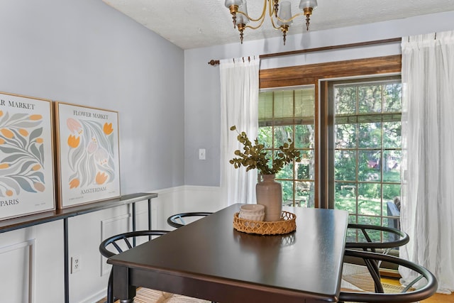 6666 Sharon Woods Blvd, Columbus, OH 43229 - dining space featuring a chandelier, healthy amount of natural light, a textured ceiling, and a wainscoted wall