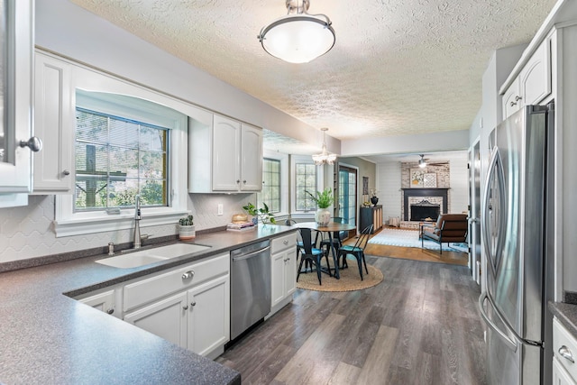 6666 Sharon Woods Blvd, Columbus, OH 43229 - kitchen with appliances with stainless steel finishes, a textured ceiling, dark countertops, plenty of natural light, and white cabinetry