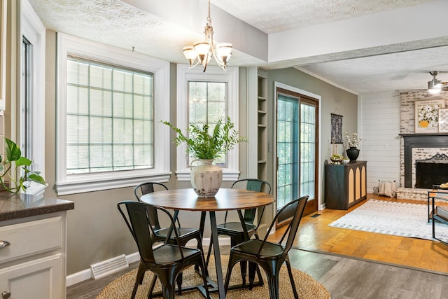 6666 Sharon Woods Blvd, Columbus, OH 43229 - dining room with a textured ceiling, a chandelier, wood finished floors, a fireplace, and built in features