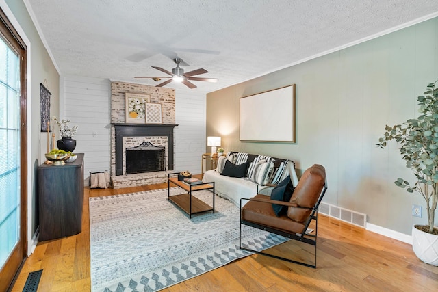 6666 Sharon Woods Blvd, Columbus, OH 43229 - living room featuring a textured ceiling, crown molding, wood finished floors, ceiling fan, and a brick fireplace