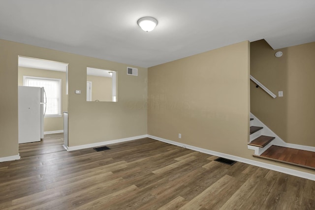 1077-1079 S James Rd, Columbus, OH 43227 - empty room featuring wood finished floors, stairway, and a smoke detector
