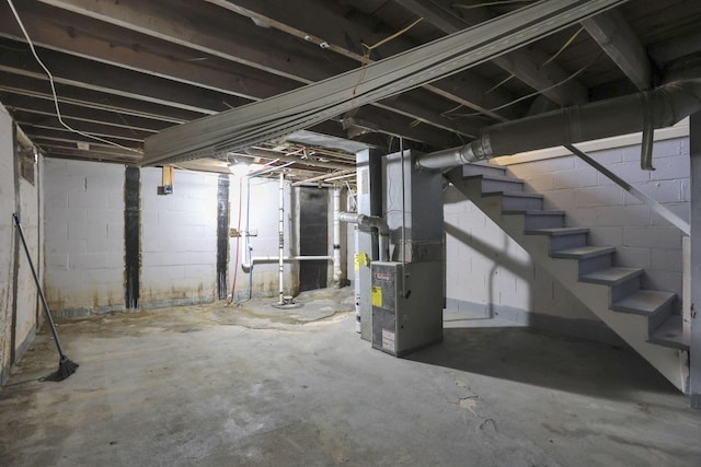 1077-1079 S James Rd, Columbus, OH 43227 - unfinished below grade area featuring heating unit, stairs, and concrete block wall