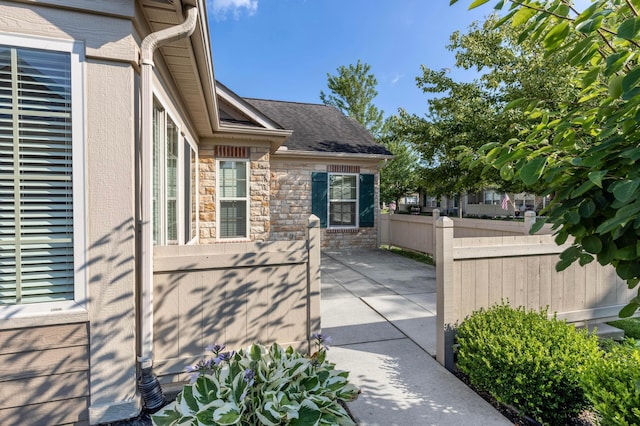 810 Lambton Cir W, Lancaster, OH 43130 - view of side of property featuring a patio, stone siding, and a shingled roof