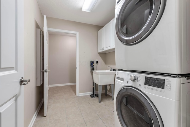 810 Lambton Cir W, Lancaster, OH 43130 - laundry room featuring estacked washer and dryer, cabinet space, and light tile patterned floors