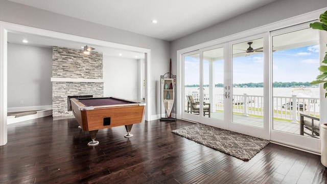 4721 W N Bank Rd, Buckeye Lake, OH 43008 - recreation room featuring dark wood-style floors, a water view, pool table, a stone fireplace, and a ceiling fan
