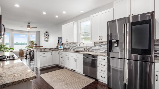 4721 W N Bank Rd, Buckeye Lake, OH 43008 - kitchen featuring appliances with stainless steel finishes, a peninsula, recessed lighting, white cabinets, and light stone countertops