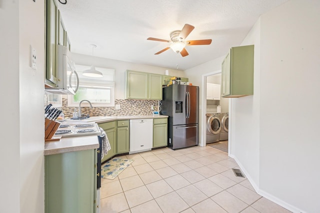 9375 Wingate Pl, Orient, OH 43146 - kitchen with green cabinets, white appliances, washing machine and clothes dryer, a ceiling fan, and light countertops