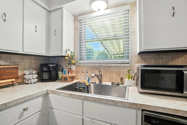 1978 Candlenut Cir, Grove City, OH 43123 - kitchen featuring stainless steel microwave, light countertops, white cabinetry, dishwashing machine, and tasteful backsplash