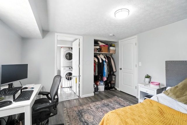 1978 Candlenut Cir, Grove City, OH 43123 - bedroom featuring estacked washer and dryer, dark wood-style floors, a closet, a desk, and a textured ceiling