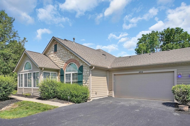 684 Old Dover Rd, Westerville, OH 43082 - ranch-style house featuring stone siding, driveway, an attached garage, and roof with shingles