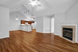 684 Old Dover Rd, Westerville, OH 43082 - unfurnished living room featuring ceiling fan, vaulted ceiling, wood finished floors, and a tile fireplace