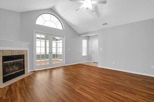 684 Old Dover Rd, Westerville, OH 43082 - unfurnished living room featuring vaulted ceiling, ceiling fan, wood finished floors, and a tile fireplace