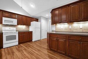 684 Old Dover Rd, Westerville, OH 43082 - kitchen with white appliances, wood finished floors, backsplash, lofted ceiling, and recessed lighting