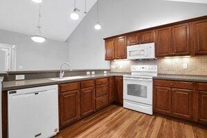 684 Old Dover Rd, Westerville, OH 43082 - kitchen with white appliances, hanging light fixtures, backsplash, a peninsula, and light wood-style flooring