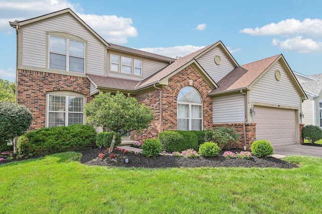 1077 Taylor Mills Dr, Reynoldsburg, OH 43068 - traditional home featuring brick siding, a garage, a front yard, and asphalt driveway