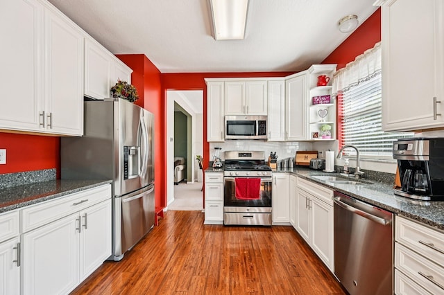 1077 Taylor Mills Dr, Reynoldsburg, OH 43068 - kitchen with stainless steel appliances, open shelves, white cabinetry, dark wood-style flooring, and dark stone countertops
