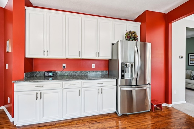 1077 Taylor Mills Dr, Reynoldsburg, OH 43068 - kitchen featuring stainless steel fridge with ice dispenser, white cabinetry, dark wood-style floors, dark stone counters, and a textured ceiling