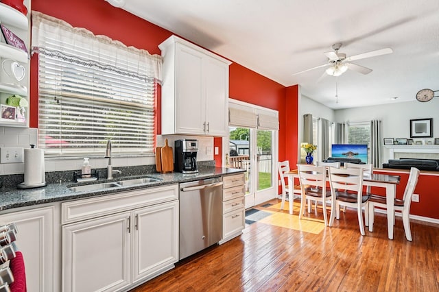 1077 Taylor Mills Dr, Reynoldsburg, OH 43068 - kitchen featuring stainless steel dishwasher, ceiling fan, white cabinets, light wood-style floors, and dark stone countertops