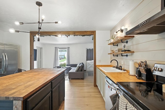 3139 Woonsocket St, Springfield, OH 45503 - kitchen with wood counters, stainless steel appliances, ventilation hood, open floor plan, and light wood finished floors