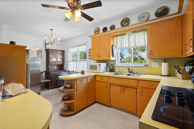 3329 Clime Rd, Columbus, OH 43223 - kitchen with black cooktop, white microwave, stainless steel refrigerator, light countertops, and a peninsula