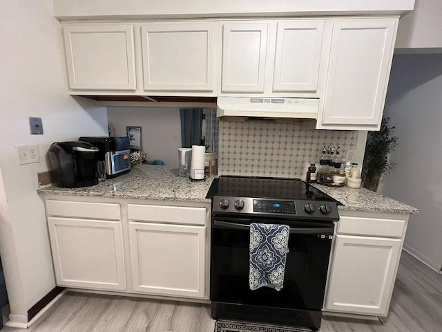 5258 Captains Ct, Columbus, OH 43220 - kitchen with electric range oven, under cabinet range hood, light wood-style floors, backsplash, and white cabinetry
