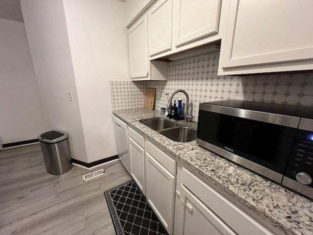 5258 Captains Ct, Columbus, OH 43220 - kitchen featuring stainless steel microwave, dishwasher, tasteful backsplash, light stone counters, and white cabinetry