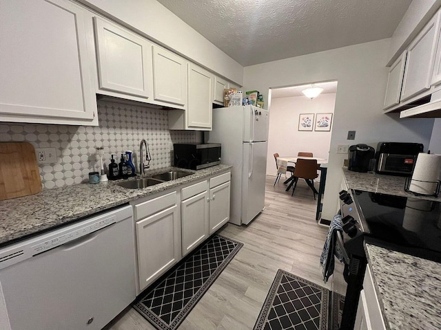 5258 Captains Ct, Columbus, OH 43220 - kitchen featuring white appliances, tasteful backsplash, light stone counters, light wood-type flooring, and a textured ceiling