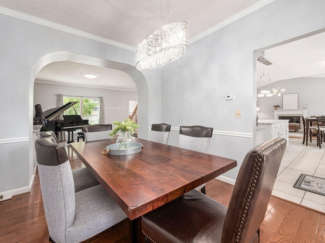 824 Lynnfield Dr, Westerville, OH 43081 - dining room with arched walkways, a chandelier, ornamental molding, and light wood-style flooring