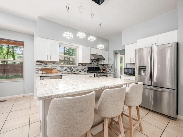 824 Lynnfield Dr, Westerville, OH 43081 - kitchen with appliances with stainless steel finishes, under cabinet range hood, light tile patterned floors, and decorative backsplash