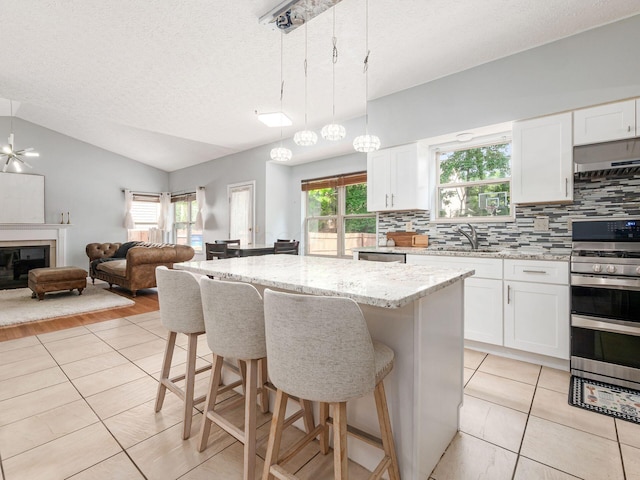 824 Lynnfield Dr, Westerville, OH 43081 - kitchen featuring appliances with stainless steel finishes, tasteful backsplash, lofted ceiling, a breakfast bar, and open floor plan
