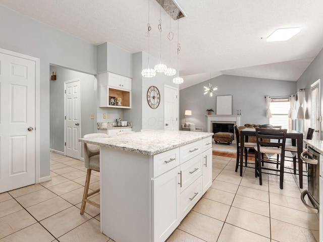 824 Lynnfield Dr, Westerville, OH 43081 - kitchen featuring vaulted ceiling, light tile patterned floors, white cabinetry, a center island, and open floor plan
