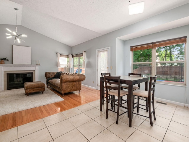 824 Lynnfield Dr, Westerville, OH 43081 - dining room featuring vaulted ceiling, light tile patterned floors, a textured ceiling, and a fireplace
