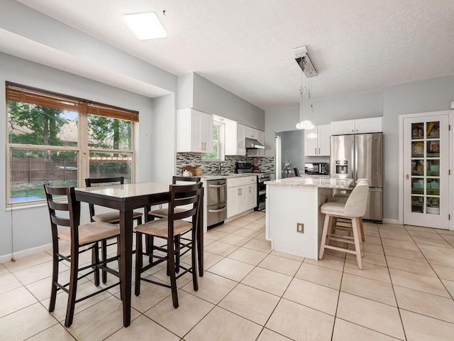 824 Lynnfield Dr, Westerville, OH 43081 - kitchen featuring stainless steel appliances, a kitchen breakfast bar, tasteful backsplash, white cabinetry, and a center island