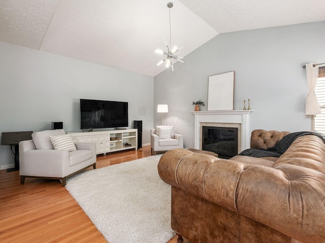 824 Lynnfield Dr, Westerville, OH 43081 - living area with vaulted ceiling, light wood finished floors, a tile fireplace, and a chandelier